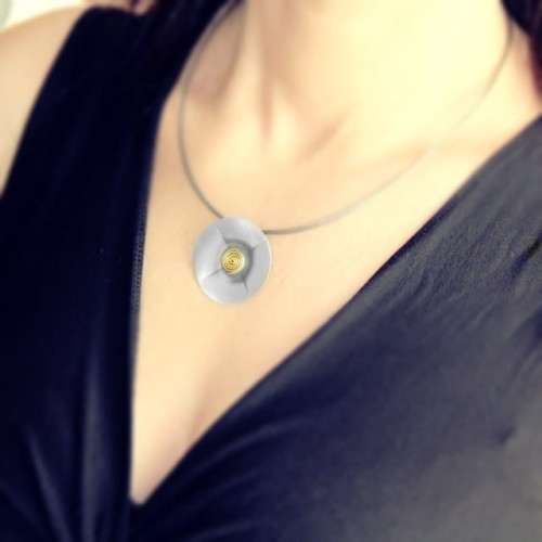 Naszyjnik srebrny ze ślimaczkiem pozłacanym – okrągła, lekko wklęsła zawieszka o średnicy 3,6 cm na lince jubilerskiej zaprezentowany na dekolcie