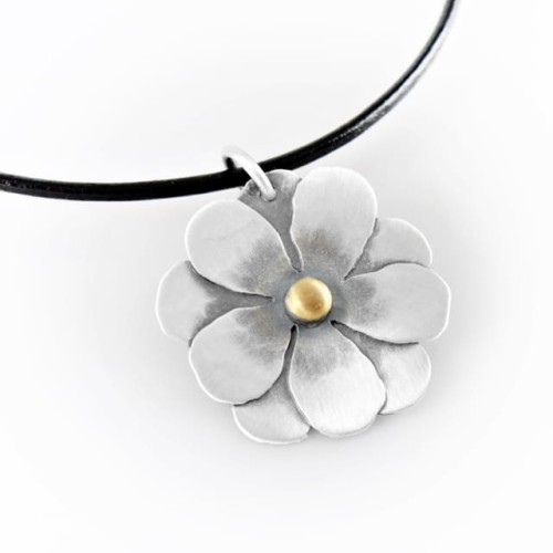 Srebrny naszyjnik z zawieszką w kształcie kwiatka i pozłacaną kuleczką w środku.