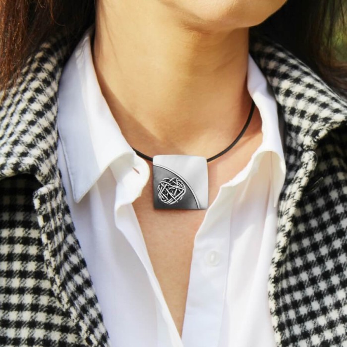 Duża zawieszka srebrna z plecionką handmade, widok naszyjnika na dekolcie