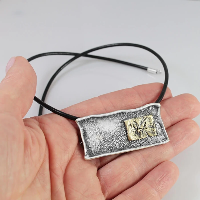 Naszyjnik w dłoni – prostokątna zawieszka handmade na rzemieniu skórzanym