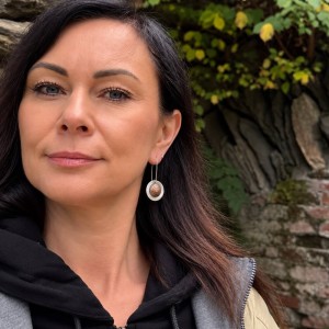 Długie kolczyki z oksydowanym miedzianym kopcem na uchu modelki